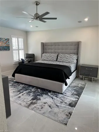 a bed sitting in a bedroom next to a window with a chandelier