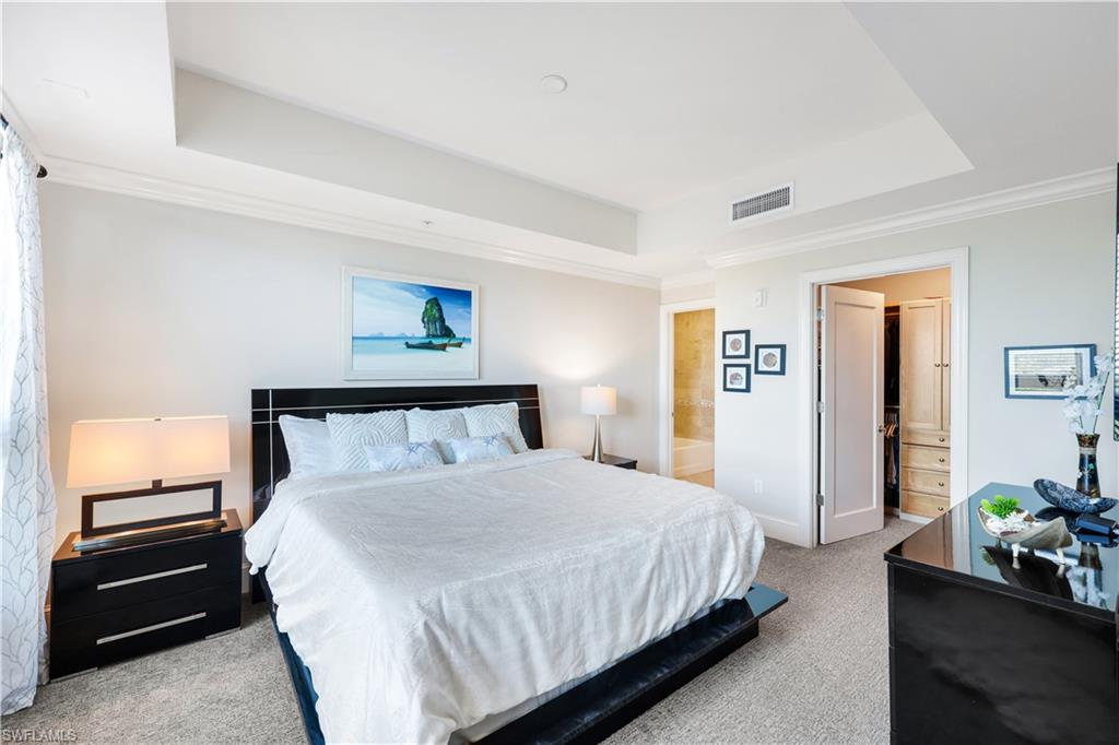 9123 Strada Place, Unit 7309 Naples, FL 34108 - Photo 13 of 48 Bedroom with crown molding, light colored carpet, a raised ceiling, and ensuite bathroom