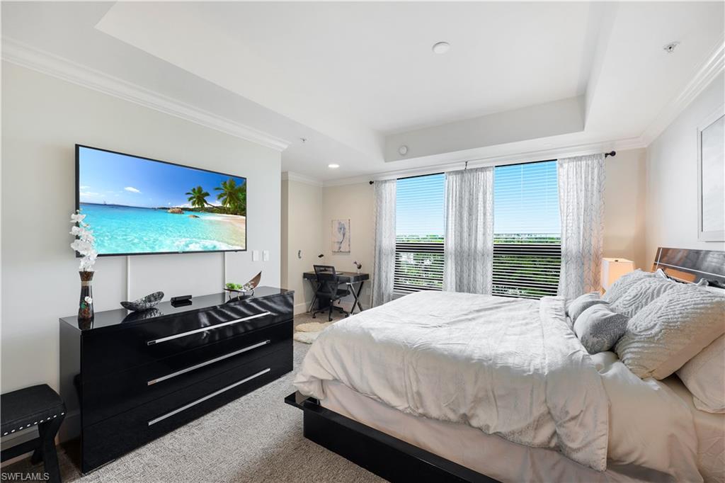 9123 Strada Place, Unit 7309 Naples, FL 34108 - Photo 14 of 48 Spacious Bedroom with crown molding, light colored carpet, a desk, and a raised ceiling