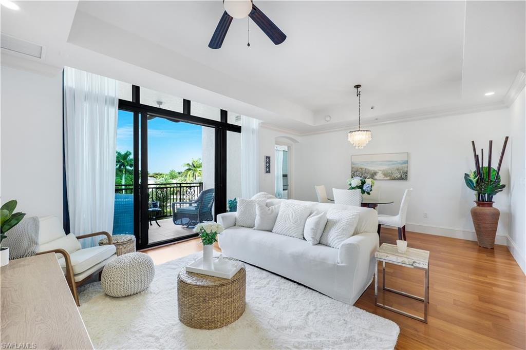 9123 Strada Place, Unit 7309 Naples, FL 34108 - Photo 2 of 48 Living room with a tray ceiling, recessed lighting, light wood-style floors, a ceiling fan, and arched walkways