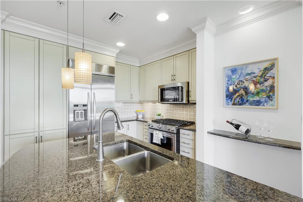 9123 Strada Place, Unit 7309 Naples, FL 34108 - Photo 6 of 46 a kitchen with stainless steel appliances granite countertop a sink a stove and a refrigerator