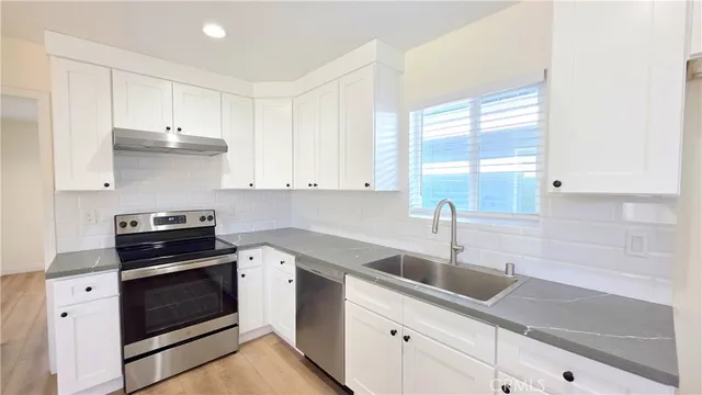 a kitchen with a sink stove and cabinets