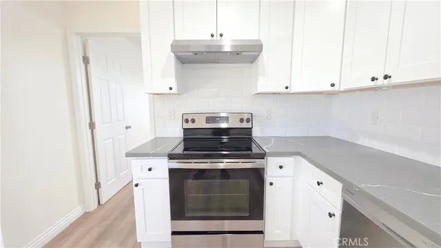 a kitchen with a stove and white cabinets