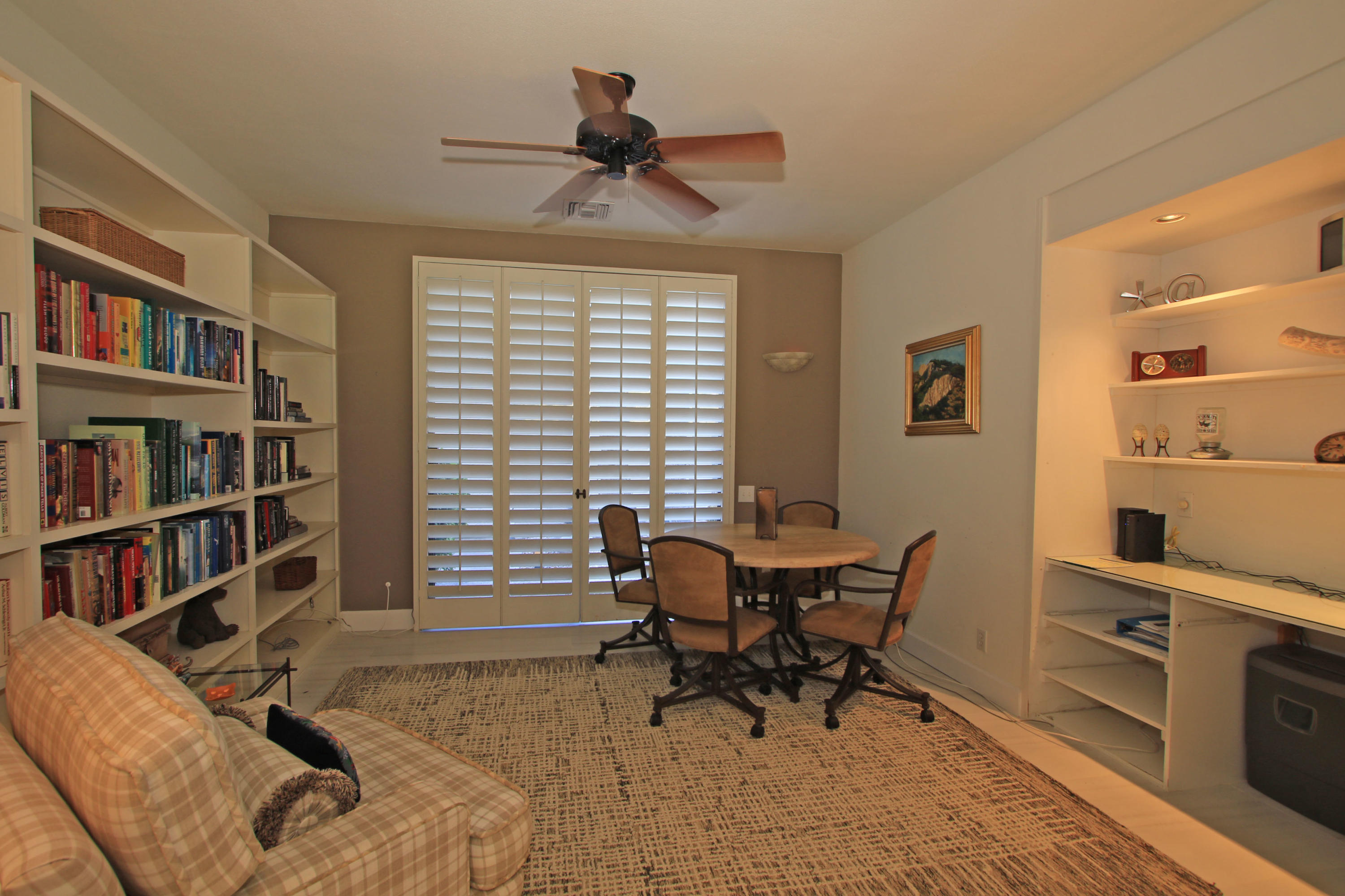 913 Inverness Drive Rancho Mirage, CA 92270 - Photo 12 of 52 a view of a workspace with furniture and a bookshelf