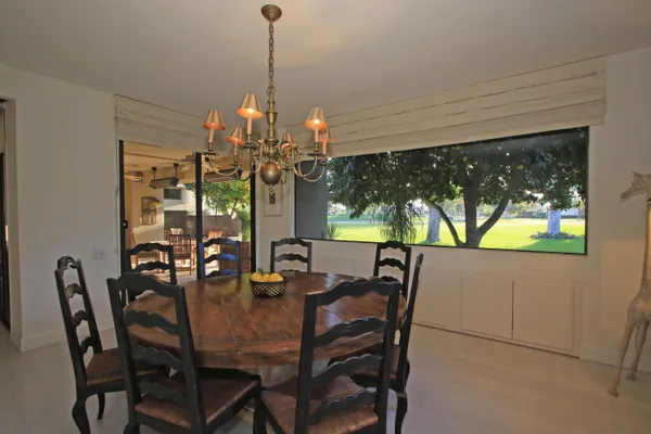 a view of a dining room with furniture a chandelier and window