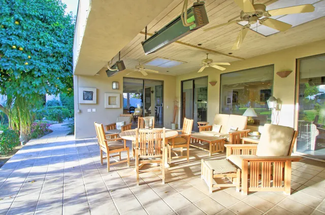 a view of a lake with a table and chairs and floor to ceiling window