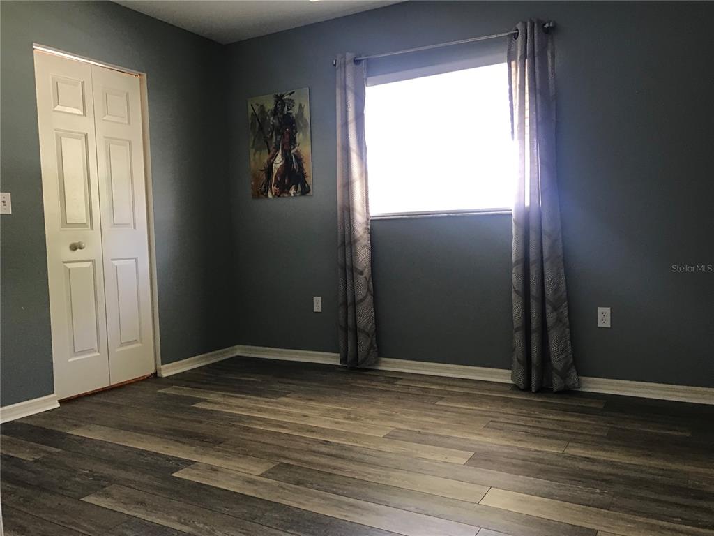 11879 Southwest 137th Loop Dunnellon, FL 34432 - Photo 17 of 37 an empty room with wooden floor cabinet and windows