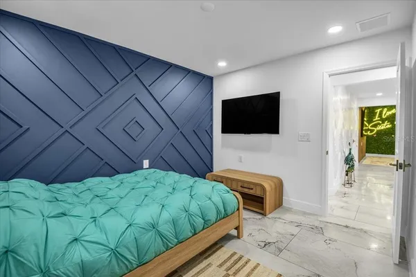 a bedroom with a bed and a flat screen tv