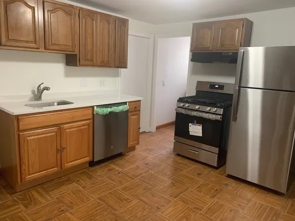 a kitchen with stainless steel appliances granite countertop a stove a refrigerator and a sink