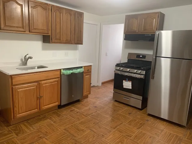 a kitchen with stainless steel appliances granite countertop a stove a refrigerator and a sink