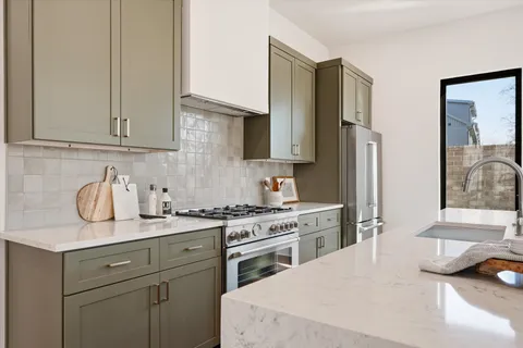 a kitchen with a table chairs refrigerator and microwave
