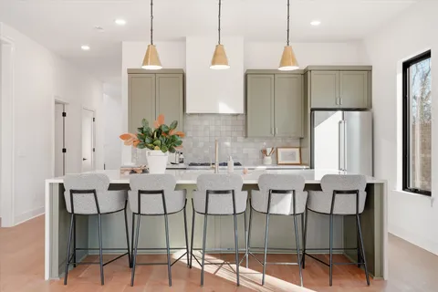 a kitchen with a dining table cabinets and stainless steel appliances