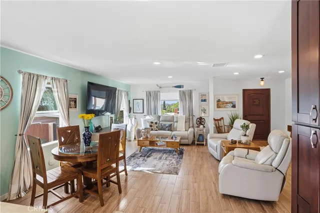 a kitchen with stainless steel appliances granite countertop a refrigerator a sink dishwasher a stove and white countertops with wooden floor