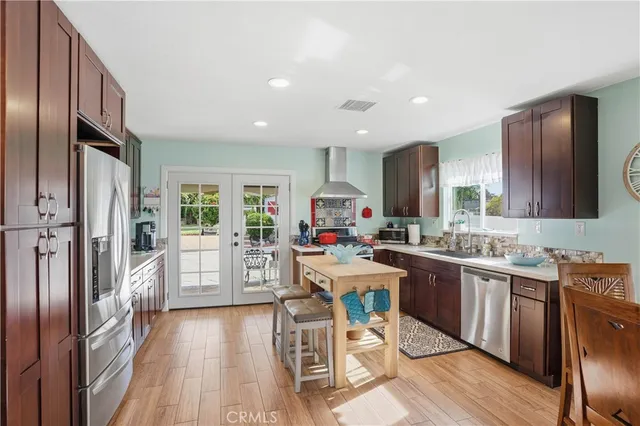 a kitchen with stainless steel appliances kitchen island granite countertop a stove refrigerator and cabinets