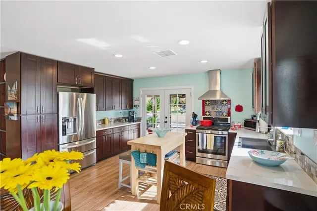 a kitchen with granite countertop stainless steel appliances a refrigerator and cabinets
