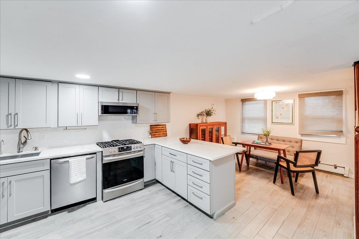 221 Terrace Avenue Jersey City, NJ 07307 - Photo 8 of 37 a kitchen with white cabinets and white appliances