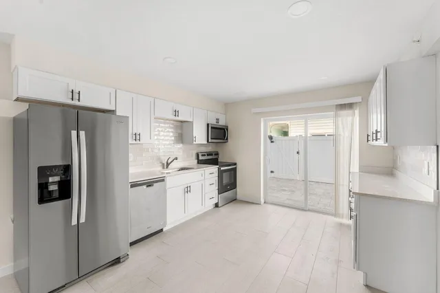 a kitchen with stainless steel appliances a refrigerator sink and cabinets