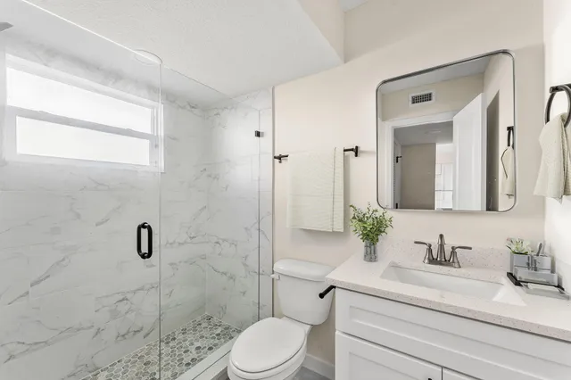 a bathroom with a sink a toilet and shower