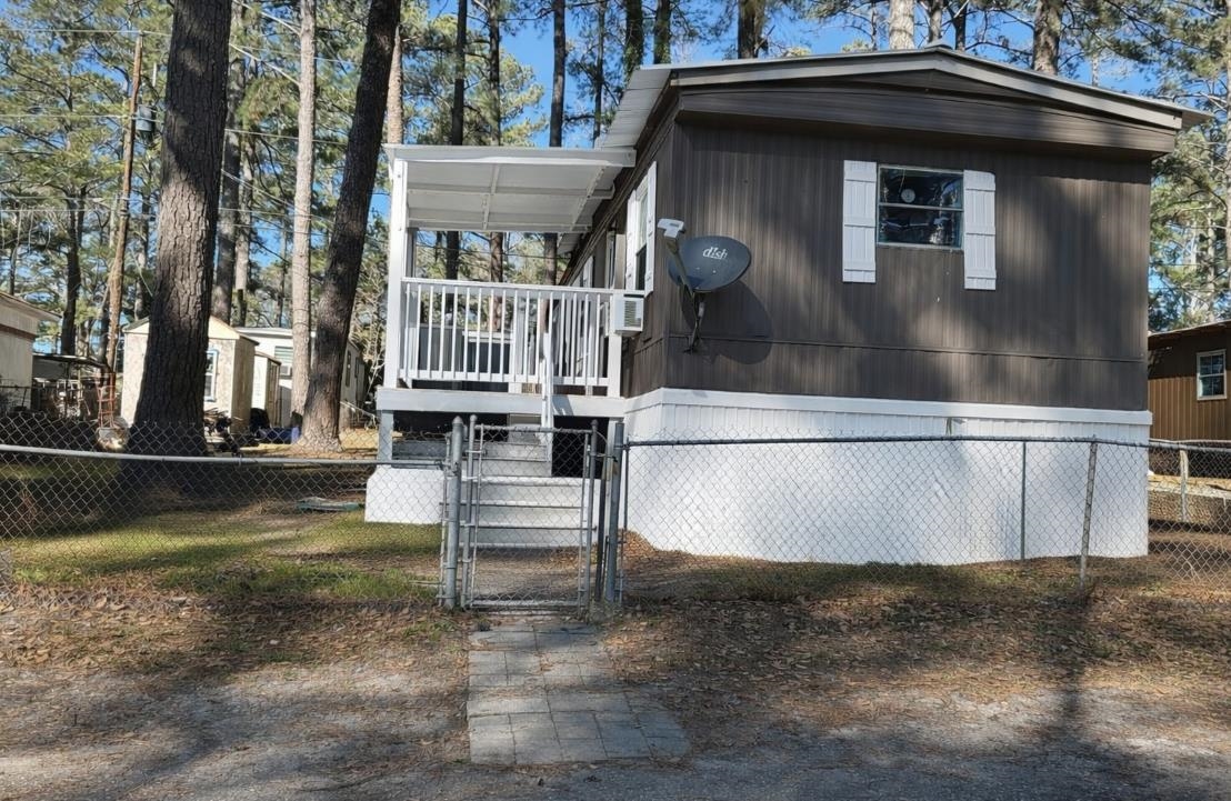 View of side of home featuring a gate and a fenced front yard