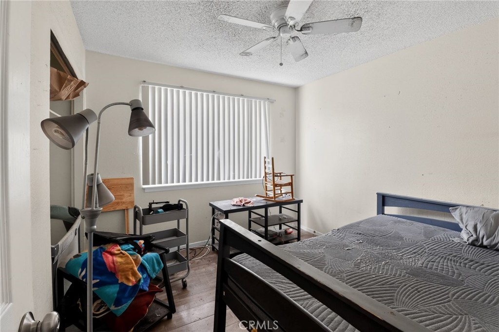 21985 Maumee Road Apple Valley, CA 92308 - Photo 21 of 30 a bedroom with a bed and a chandelier