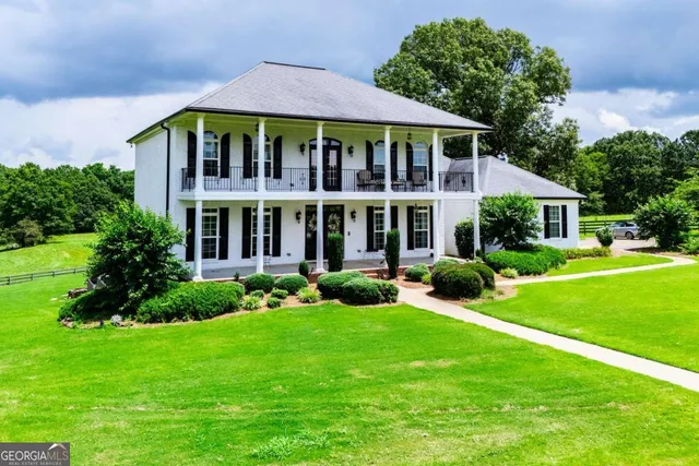 a view of a house with a yard and potted plants