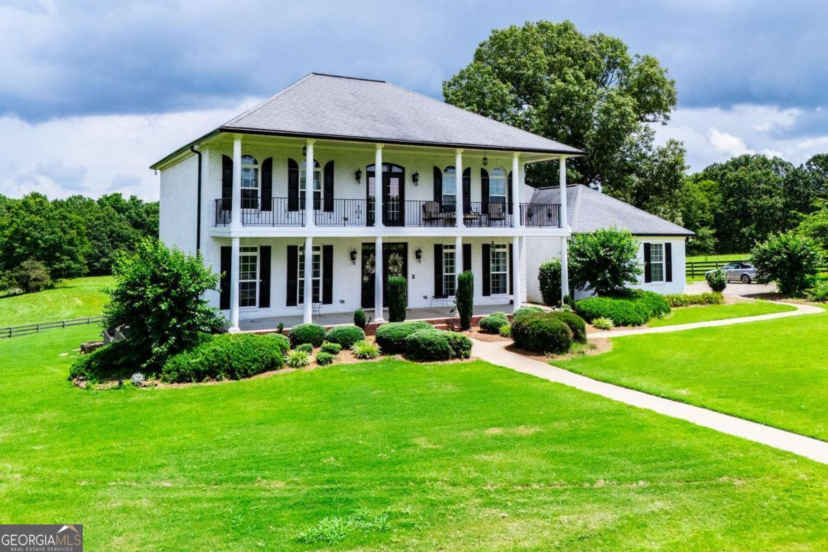 a view of a house with a yard and potted plants
