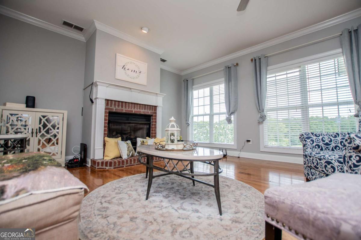 1074 Glenloch Road Roopville, GA 30170 - Photo 16 of 98 a living room with furniture a fireplace and large windows