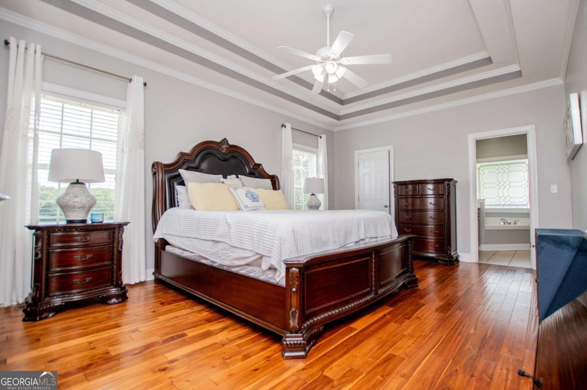 1074 Glenloch Road Roopville, GA 30170 - Photo 25 of 98 a spacious bedroom with a bed and wooden floor
