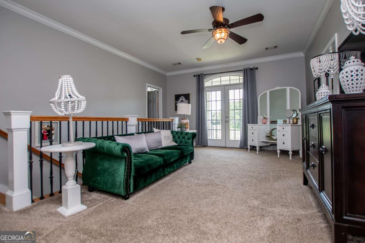 1074 Glenloch Road Roopville, GA 30170 - Photo 31 of 98 a living room with furniture a chandelier and a flat screen tv