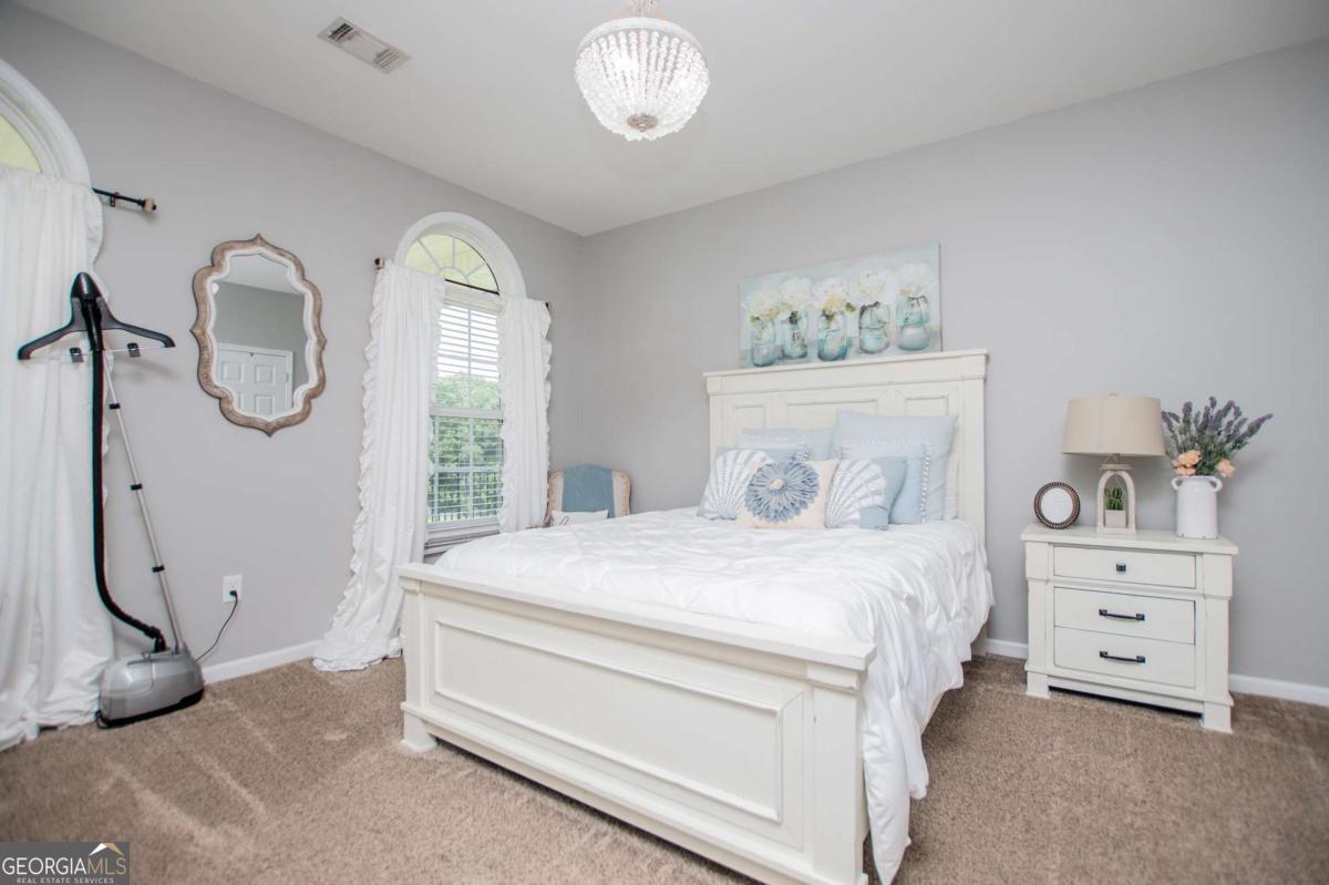 1074 Glenloch Road Roopville, GA 30170 - Photo 38 of 98 a bedroom with a bed and a chandelier