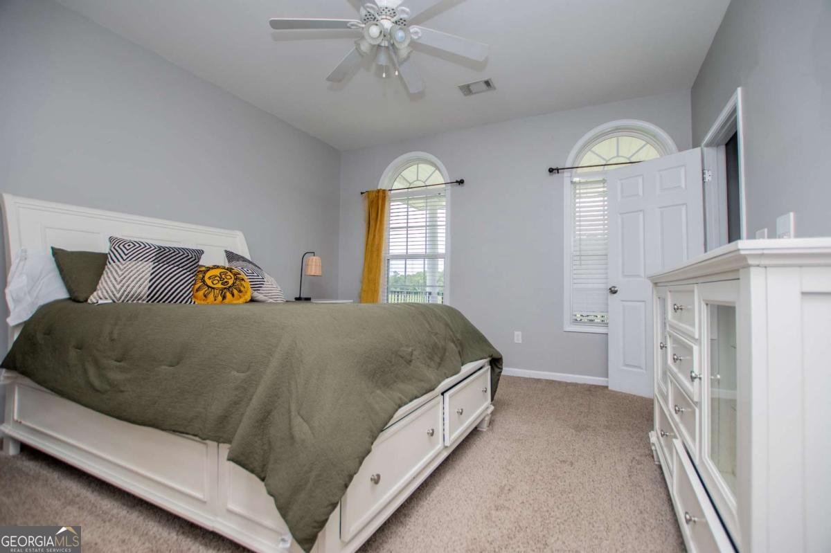 1074 Glenloch Road Roopville, GA 30170 - Photo 45 of 98 a spacious bedroom with a bed and a chandelier