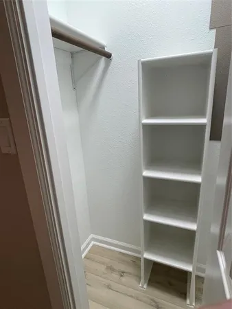 a view of walk in closet with empty racks