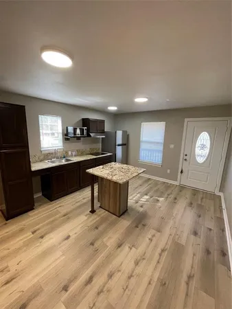a kitchen with granite countertop a stove a sink and a refrigerator