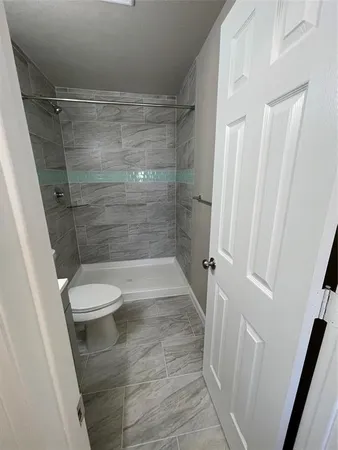 a bathroom with a toilet and a shower