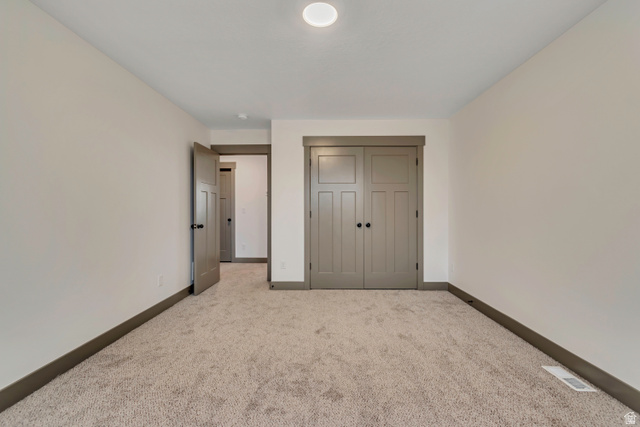 3317 South 1000 West, Unit 6010 Logan, UT 84321 - Photo 32 of 34 Unfurnished bedroom featuring light carpet and a closet