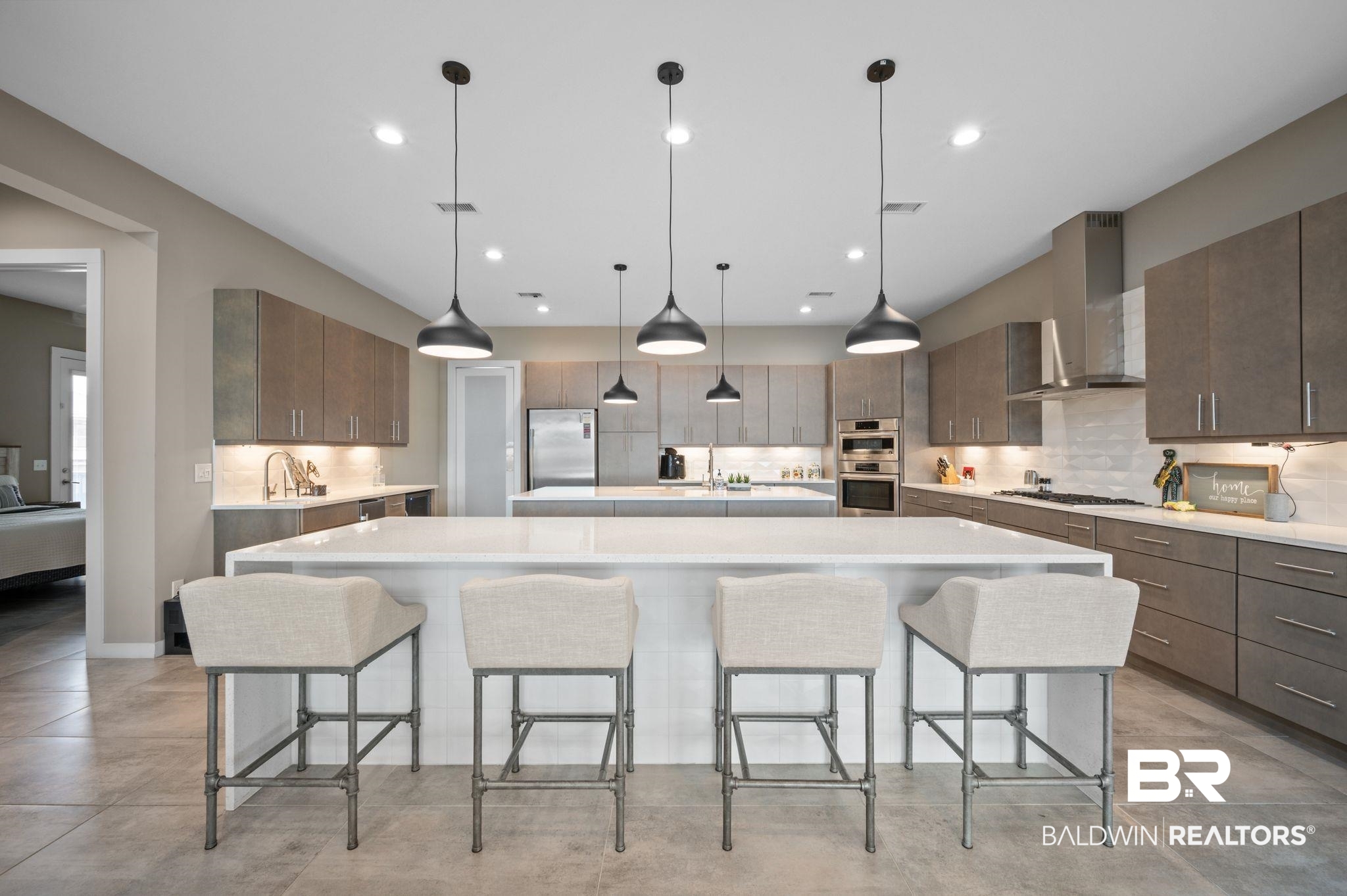 3840 Cotton Way Orange Beach, AL 36561 - Photo 13 of 75 Kitchen featuring a kitchen bar, hanging light fixtures, a spacious island, and wall chimney range hood