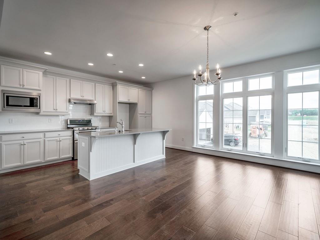 122 Gress Road Cranberry Township, PA 16066 - Photo 13 of 25 a large kitchen with hardwood floor a large window and white cabinets