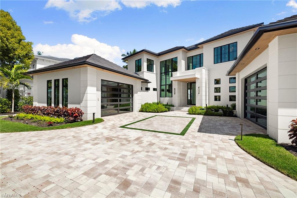 2345 Tarpon Road Naples, FL 34102 - Photo 40 of 43 Modern home with stucco siding, decorative driveway, and an attached garage
