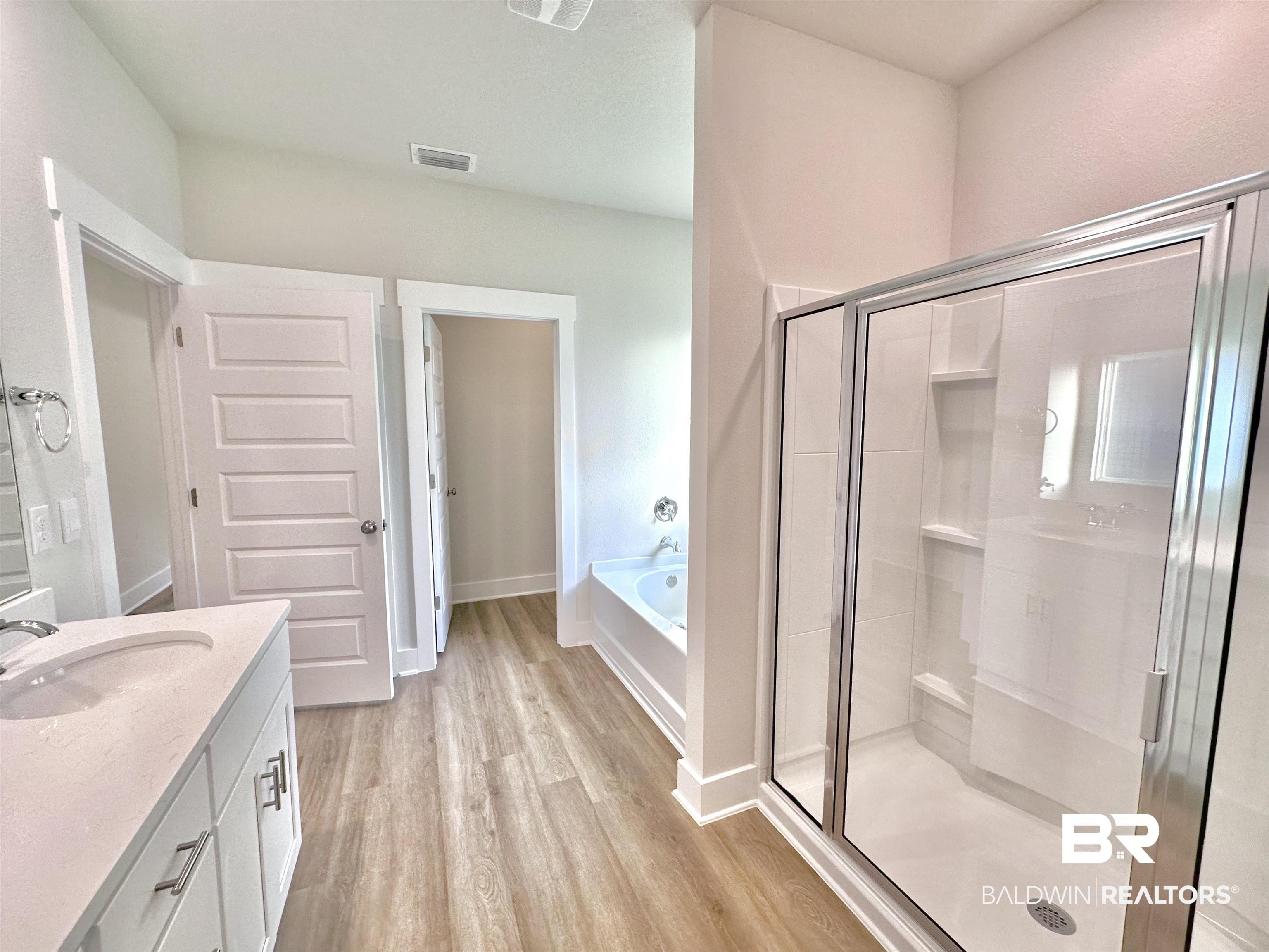 342 Barndling Street Fairhope, AL 36532 - Photo 17 of 50 Bathroom with vanity, shower with separate bathtub, and wood-type flooring