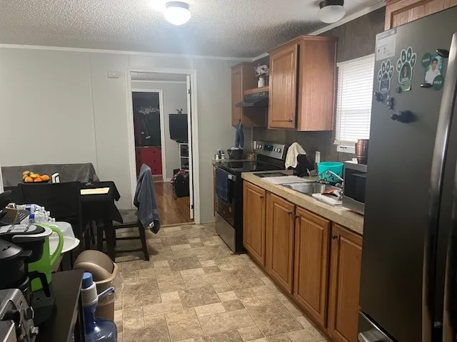 a kitchen with a sink refrigerator and cabinets