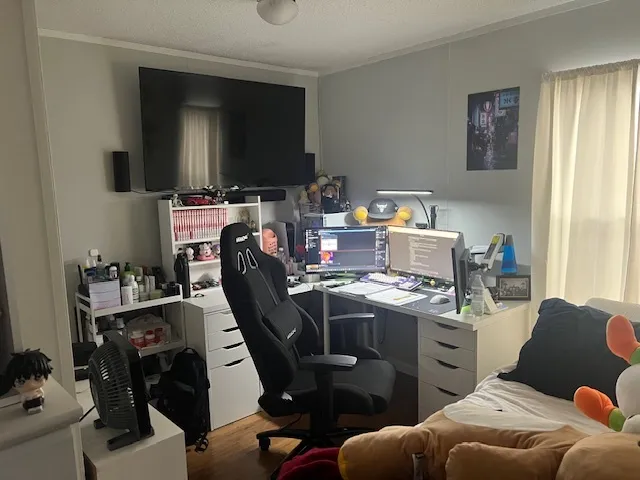 a view of a workspace with furniture and a window