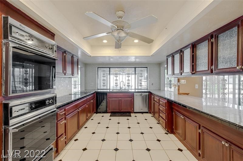 2249 Darwin Circle Henderson, NV 89014 - Photo 11 of 24 Kitchen featuring stainless steel appliances, a raised ceiling, dark stone counters, a peninsula, and recessed lighting