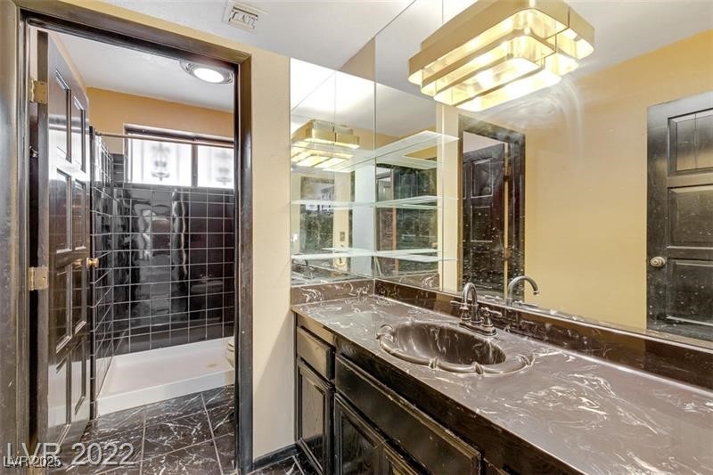 2249 Darwin Circle Henderson, NV 89014 - Photo 19 of 24 Full bath with dark marble finish floors, vanity, and a shower stall