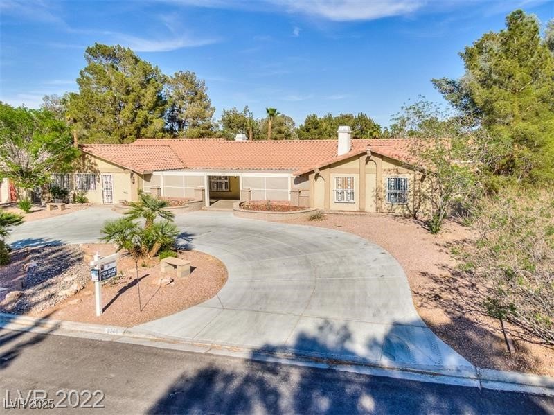 2249 Darwin Circle Henderson, NV 89014 - Photo 6 of 24 View of front of property with curved driveway, a tiled roof, a chimney, and stucco siding