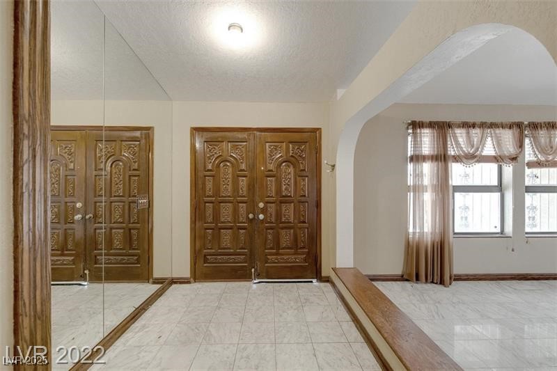 2249 Darwin Circle Henderson, NV 89014 - Photo 7 of 24 Foyer entrance featuring arched walkways and a textured ceiling