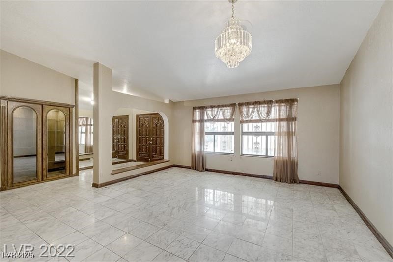 2249 Darwin Circle Henderson, NV 89014 - Photo 8 of 24 Empty room with baseboards and a chandelier