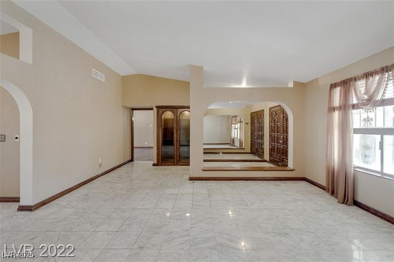 2249 Darwin Circle Henderson, NV 89014 - Photo 9 of 24 Spare room with arched walkways and vaulted ceiling