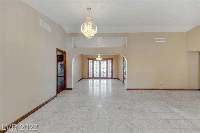 2249 Darwin Circle Henderson, NV 89014 - Photo 10 of 24 Spare room with arched walkways and a chandelier