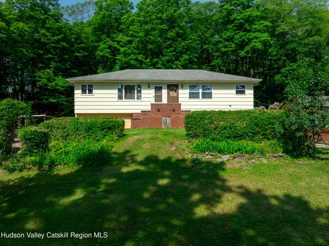a front view of house with yard and green space