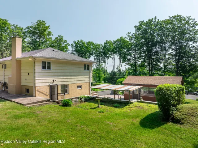 a view of a house with a backyard and a patio